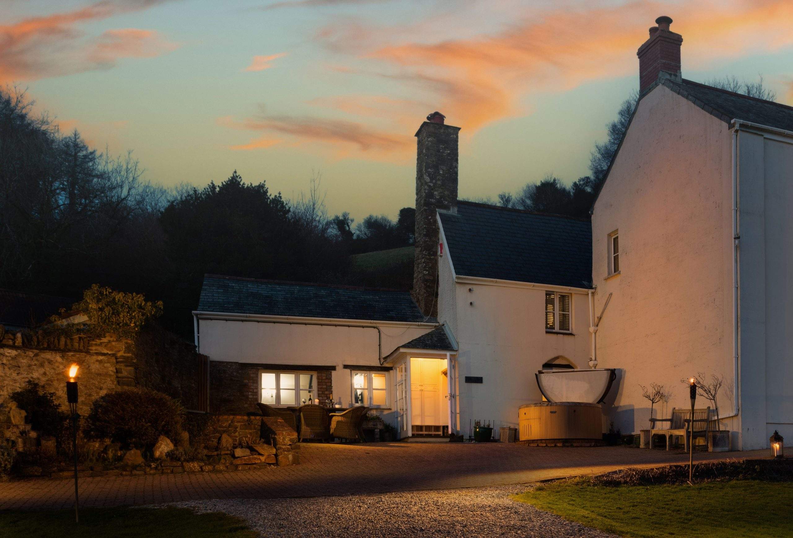 Old Farmhouse at Coulscott near Combe Martin at dusk, with a hot tub on the terrace